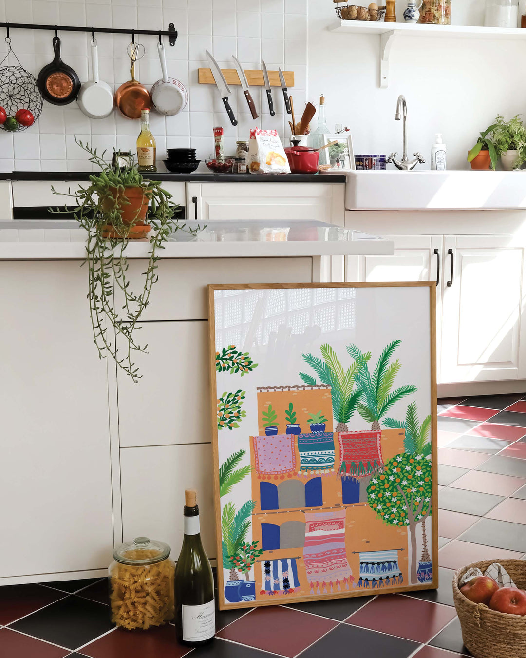 Framed Artwork of a terracotta building with vibrant rugs hanging from balconies, surrounded by lush greenery and palm trees, by Little Berries Studio.
