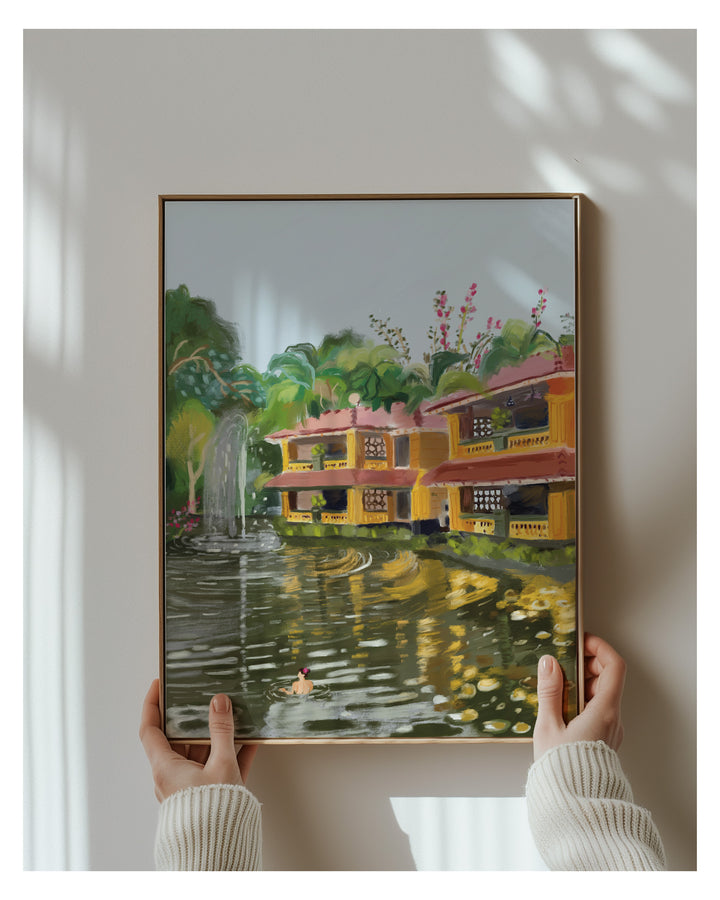 Framed painting of a scenic landscape with houses and trees from Bhubaneswar held by a person.