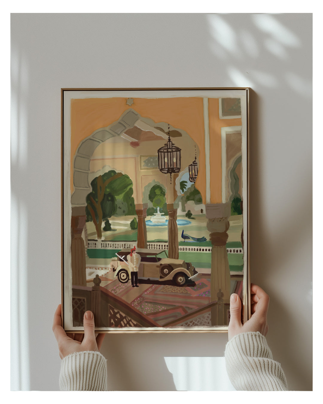 Framed artwork of a vintage car in an ornate setting held by two hands.