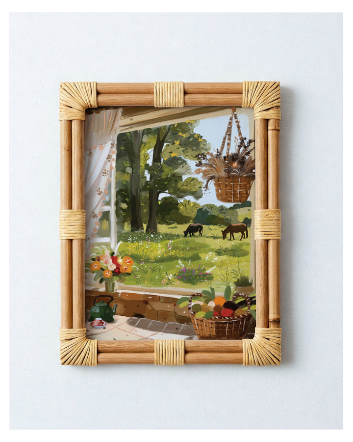 Rattan-framed Art print with a garden scene.