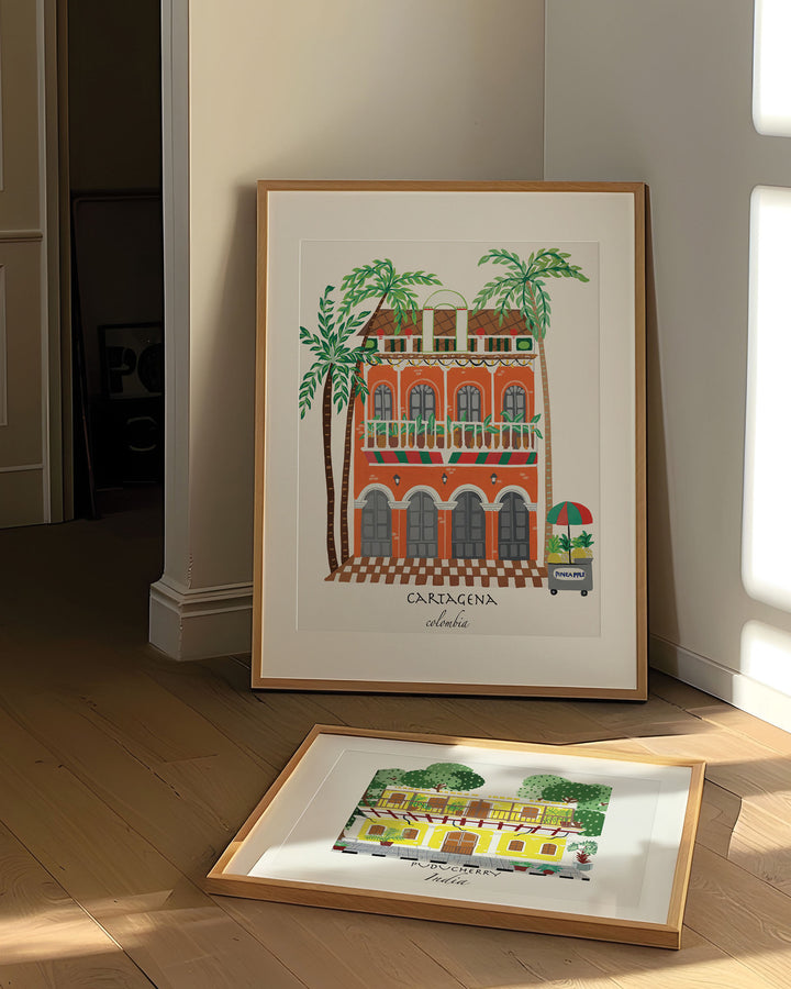 Framed Artwork of a charming Cartagena building with vibrant orange facade, green balconies, and palm trees, capturing the lively spirit of Colombia.