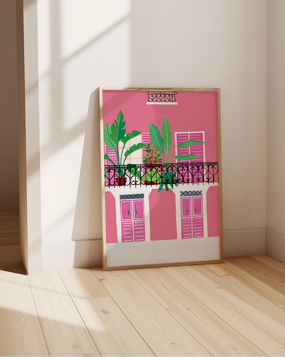 Framed Art Print titled 'Door Bloom Balcony' by Little Berries Studio, propped against a bright wall, in a sunlit room.
