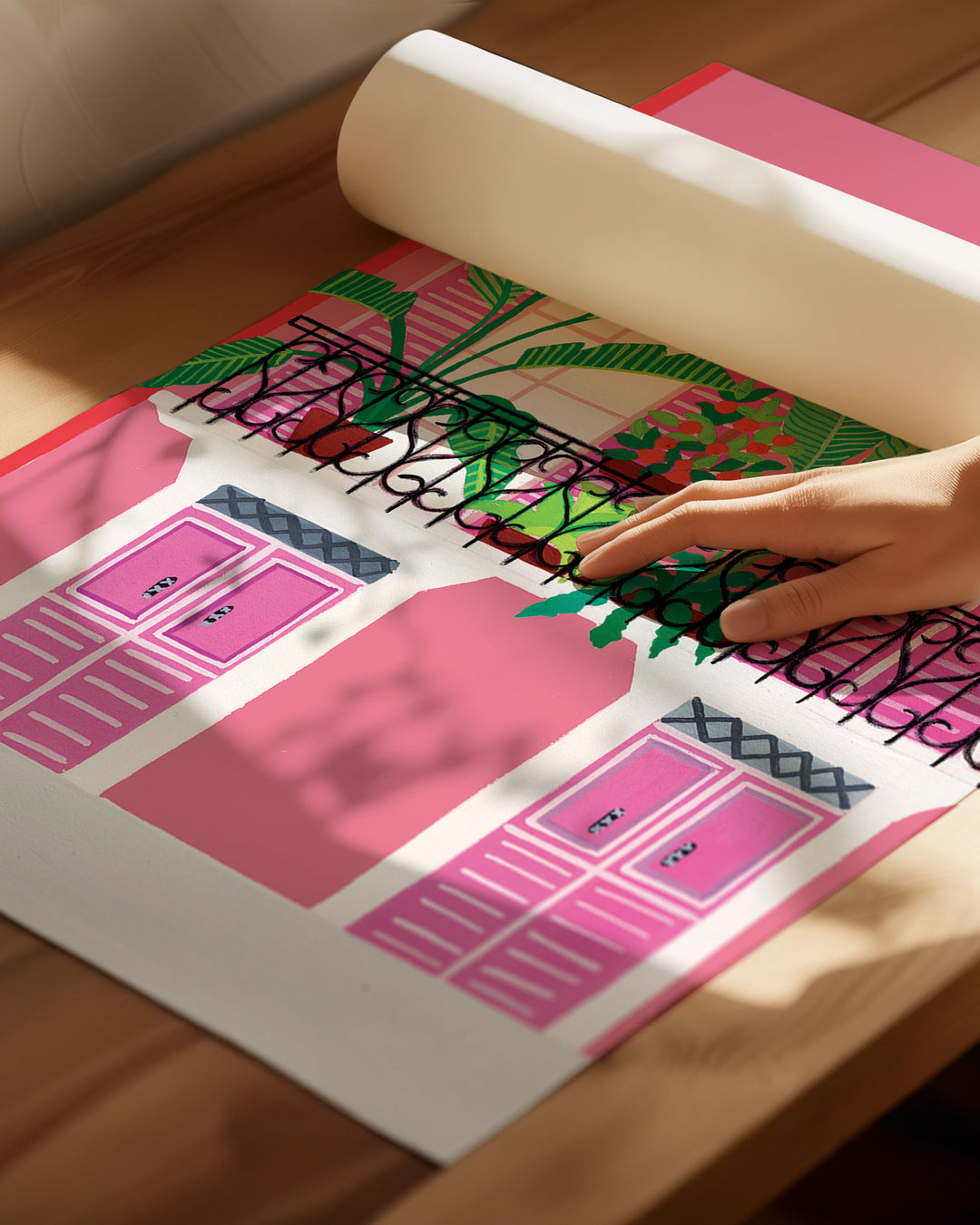 An Archival Art Print of a vibrant pink building with a black wrought-iron balcony adorned with potted tropical plants and bold pink shutters.
