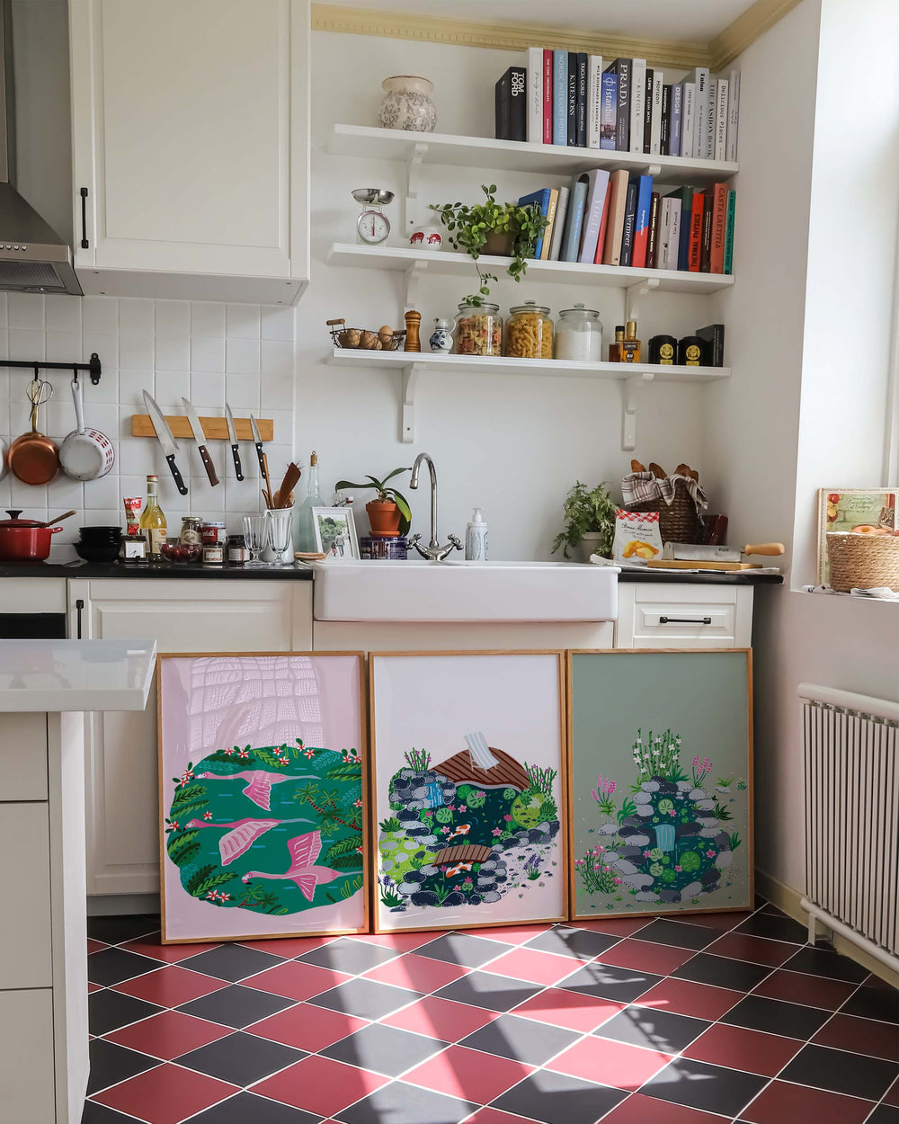 Three Framed Tropical Art Prints created by Little Berries Studio, leaning against a kitchen island with a cozy and rustic decor.