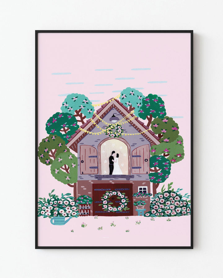 Black Framed Art Print of a couple embracing inside a small cottage adorned with flowers and surrounded by colourful trees, with a pink sky in the background created by Little Berries Studio.