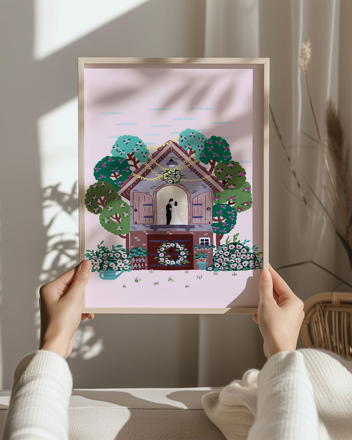 Beautiful hands holding a Framed Art Print titled "Floral Romance" featuring a romantic moment inside a cosy cottage surrounded by lush trees and vibrant flowers.