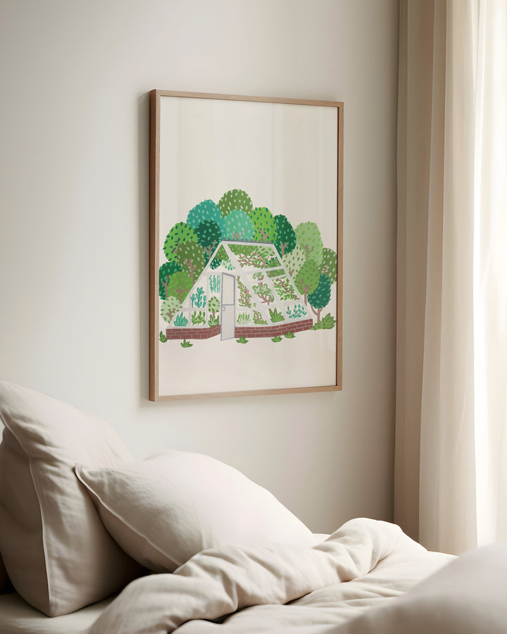 Framed Wall Art by Little Berries Studio depicting an illustrated greenhouse filled with plants, surrounded by a lush landscape of green trees.