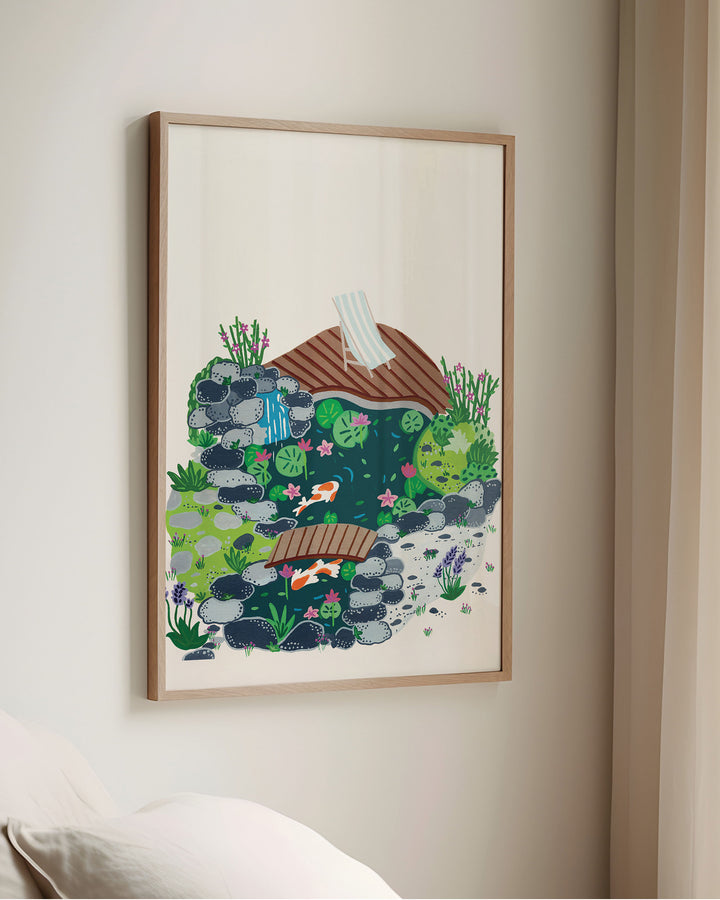 Framed Artwork of a peaceful garden scene with a small koi pond, surrounded by rocks, blooming plants, and a wooden deck with a striped deck chair.