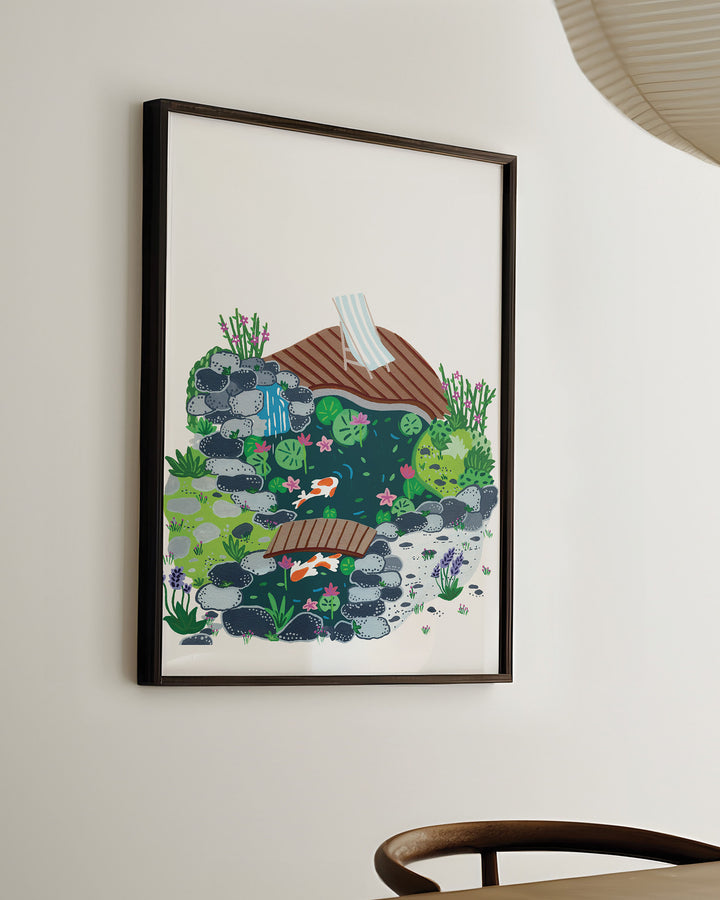 Ready-to-hang Framed Artwork of a peaceful garden scene with a small koi pond, surrounded by rocks, blooming plants, and a wooden deck with a striped deck chair.