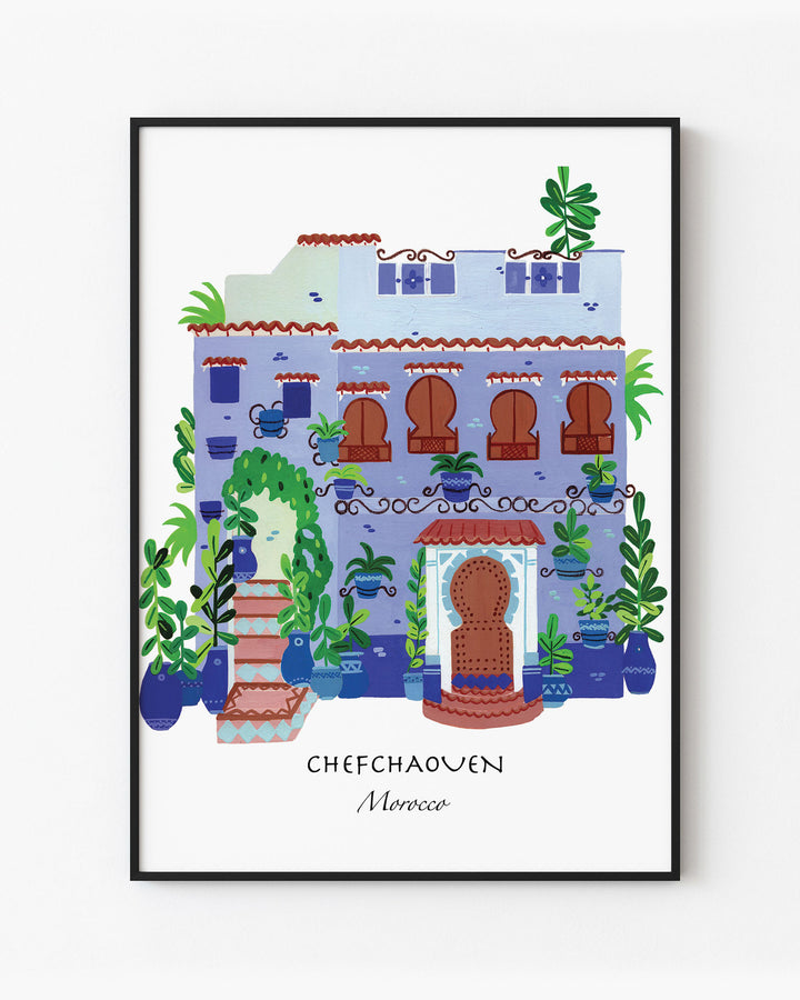 Black Framed Artwork of a traditional Moroccan house in Chefchaouen by Little Berries Studio, featuring blue and white architecture, arched windows, and lush green plants.