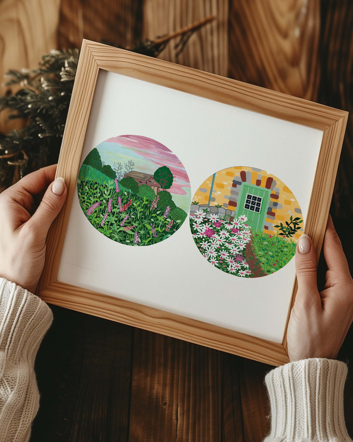 Person holding a Framed Artwork of two circular nature illustrations: one depicting a field of tall green plants and wildflowers, the other featuring a stone house with a green door.
