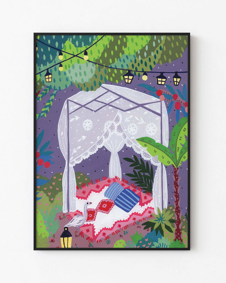 Black Framed Art Print depicting a cozy outdoor scene under a canopy of trees. The centre features a draped canopy bed adorned with lace curtains, resting on a patterned red and white blanket with colourful cushions.