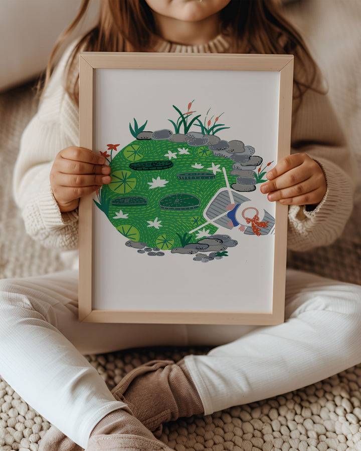Kid holding a Framed Artwork "Pondside Dreams" captures a serene pond scene filled with lily pads and vibrant greenery.
