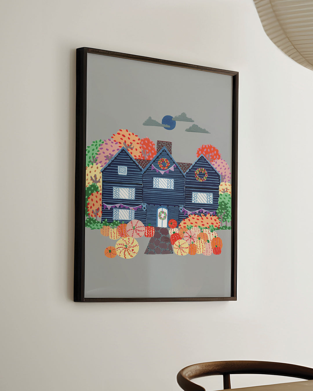 Ready-to-hang  Framed Artwork of a cosy, orange Victorian house surrounded by trees, capturing the essence of autumn with festive details and warm seasonal colours.
