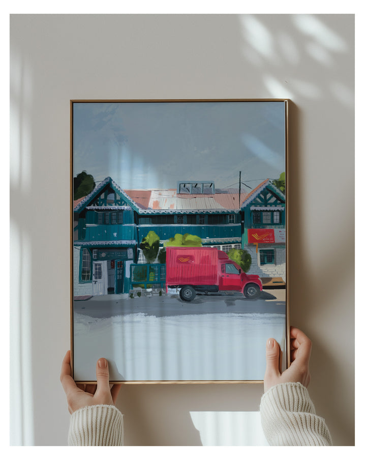 Framed artwork of a red truck in front of a Shimla Post Office held by two hands.