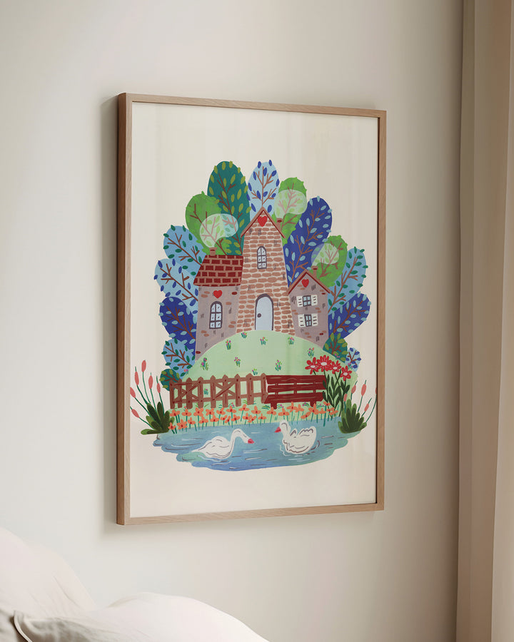 Framed Wall Art of 'Smokehouse Lakeside Serenity' a cozy stone house by a serene lake with two swans, surrounded by colourful trees and flowers, placed in a sun-lit room.