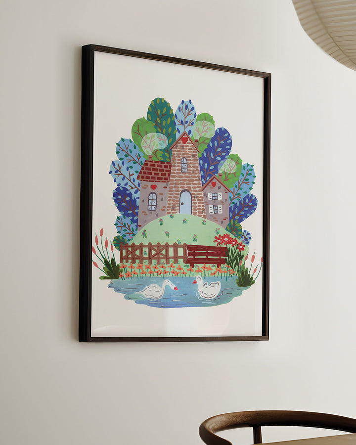 Ready-to-Hang Framed Wall Art  'Smokehouse Lakeside Serenity' a cozy stone house by a serene lake with two swans, surrounded by colourful trees and flowers, placed in a sun-lit room.