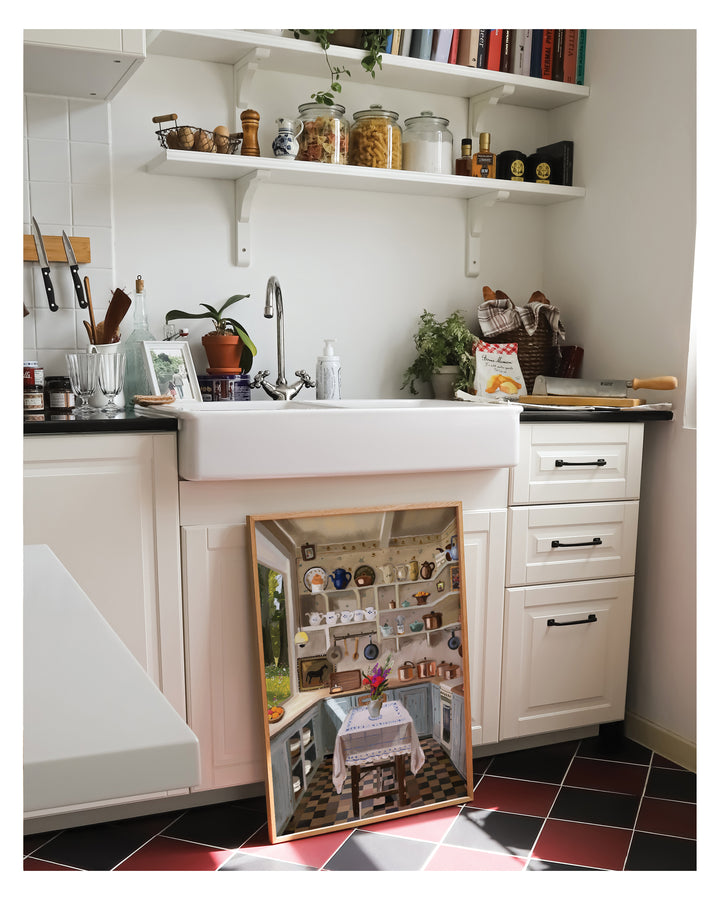 Small kitchen with a framed Artwork showing a miniature model of the same kitchen.