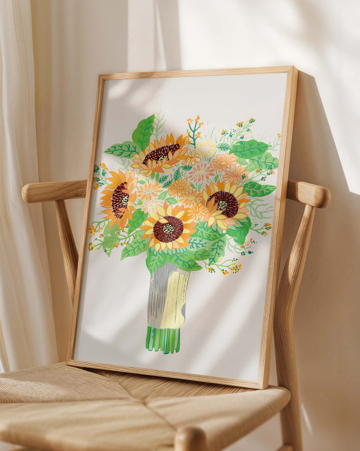 Framed Art Print titled 'Sunny Serenade' by Little Berries Studio, placed on a wooden chair in a softly lit room.