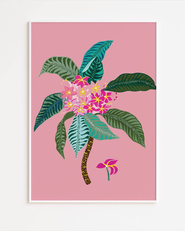 White Framed Artwork titled 'Tropical Bloom', featuring vivid floral patterns set against a soft pink background.