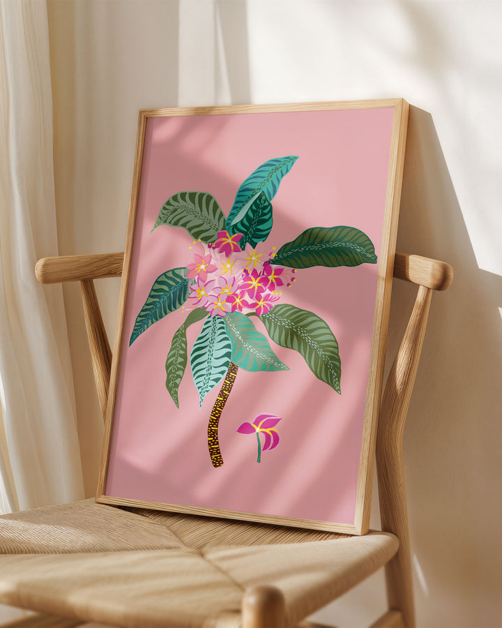 Framed Art Print titled 'Tropical Bouquet' by Little Berries Studio, placed on a wooden chair in a softly lit room.