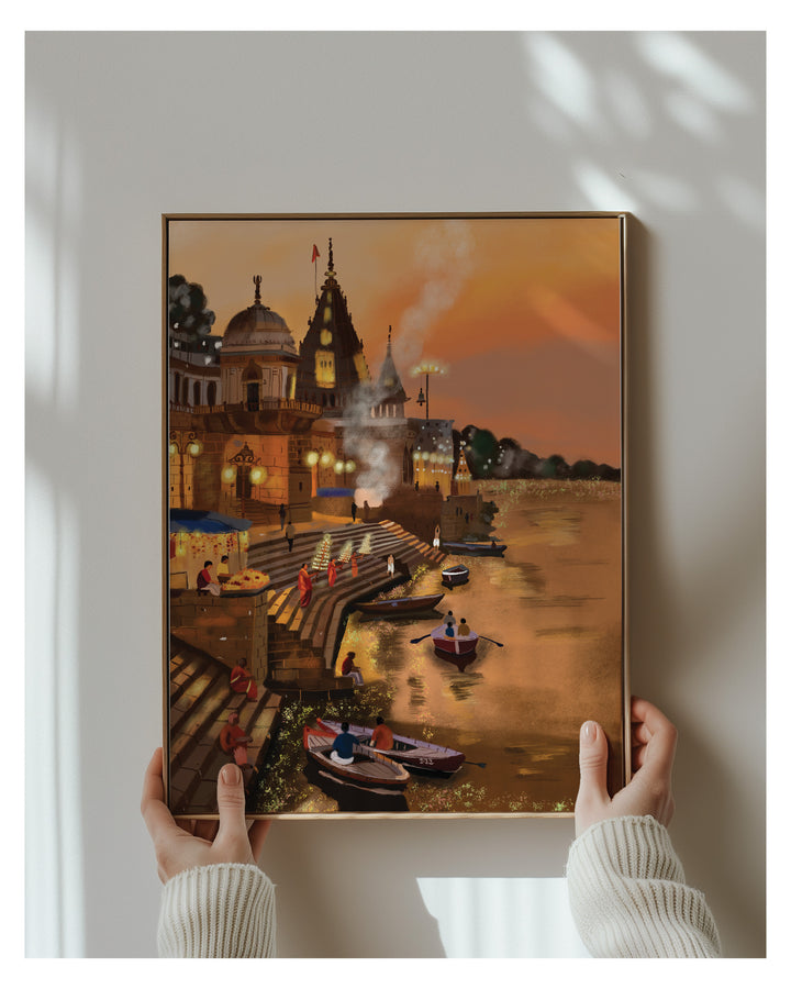 Framed artwork of a Varanasi ghat with boats and people on a river, held by two hands.