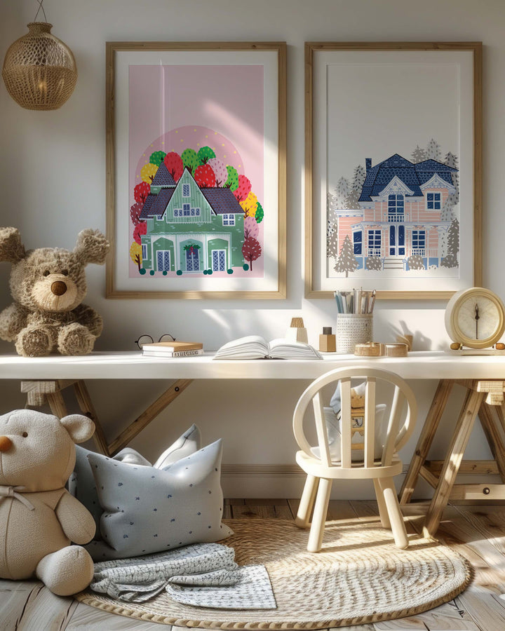 It features a cosy children's corner with warm, inviting decor. The focus is on two framed Art Prints. The Print on the left depicts a quaint green house surrounded by vibrant autumn trees.The right Print shows a Victorian-style house enveloped in a serene winter setting.