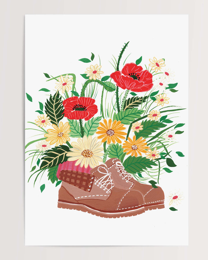 An Art Print, titled 'Wildflower Walk' features a brown hiking boot filled with an array of vibrant wildflowers, including red poppies, yellow daisies, and other colourful blossoms.